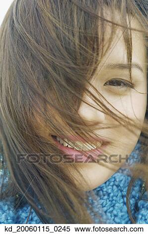 Young windblown woman smiling for the camera View Large Photo Image Stock Photography - Young windblown woman smiling for the camera. Fotosearch