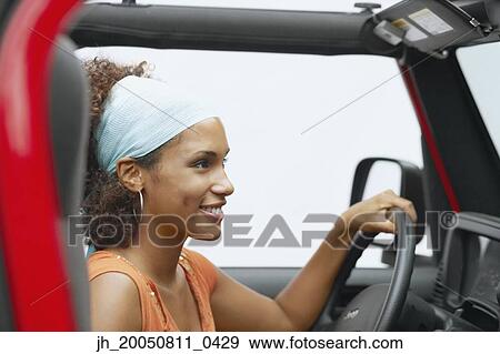 Stock Photo - Young woman driving a car. Fotosearch