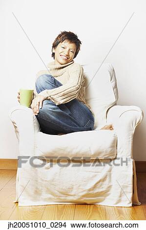 Picture - Young woman having a cup of coffee. Fotosearch