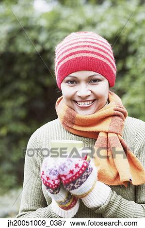 Young woman having a cup of coffee outdoors View Large Photo Image Stock Photo - Young woman having a cup of coffee outdoors. Fotosearch
