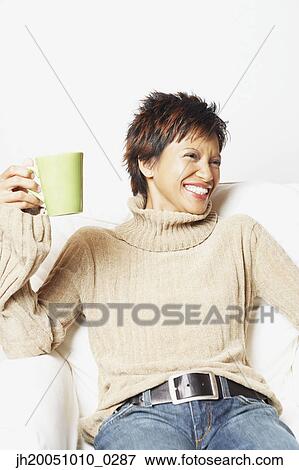 Young woman having a cup of coffee View Large Photo Image Stock Photo - Young woman having a cup of coffee. Fotosearch