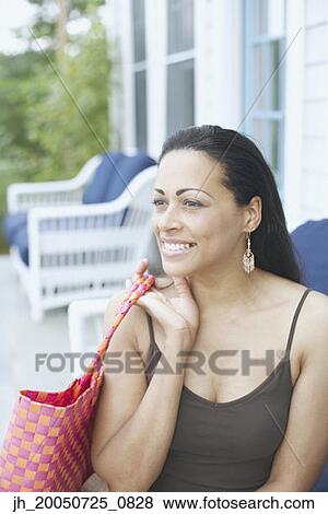 Young woman holding a purse View Large Photo Image Stock Photo - Young woman holding a purse. Fotosearch