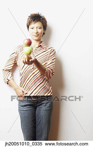 Young woman holding a stack of apples View Large Photo Image Stock Photography - Young woman holding a stack of apples. Fotosearch