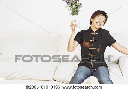 Young woman holding a vase of flowers View Large Photo Image Stock Photograph - Young woman holding a vase of flowers. Fotosearch