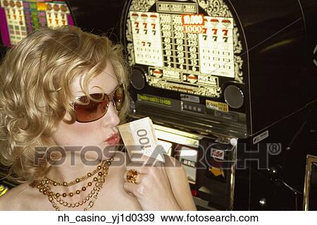 Stock Photo - Young woman holding her winnings at the casino. Fotosearch