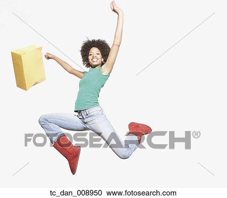 Stock Image - Young woman jumping for joy. Fotosearch