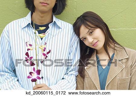 Stock Image - Young woman leaning her head on boyfriend's shoulder. Fotosearch