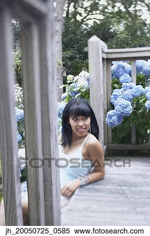 Young woman leaning on her porch View Large Photo Image Stock Photography - Young woman leaning on her porch. Fotosearch