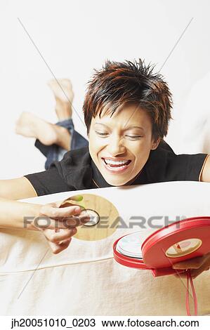 Young woman picking out a CD View Large Photo Image Stock Image - Young woman picking out a CD. Fotosearch