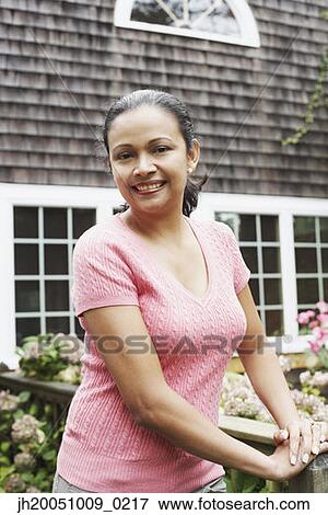 Stock Photo - Young woman posing for the camera outdoors. Fotosearch