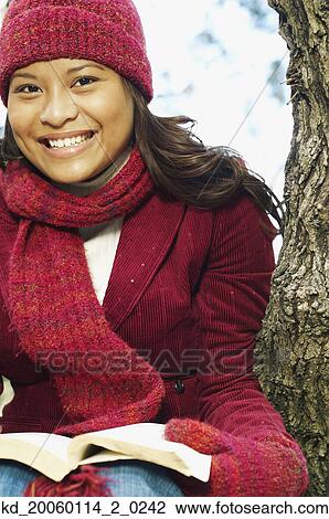 Young woman reading outdoors View Large Photo Image Stock Image - Young woman reading outdoors. Fotosearch