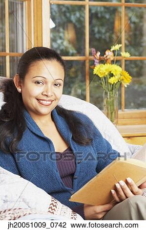 Stock Image - Young woman reading. Fotosearch