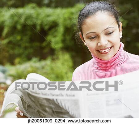 Young woman reading the newspaper View Large Photo Image Picture - Young woman reading the newspaper. Fotosearch