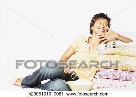 Stock Image - Young woman relaxing among blankets. Fotosearch