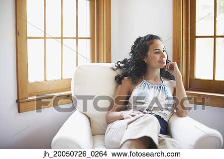 Picture - Young woman relaxing in an armchair. Fotosearch