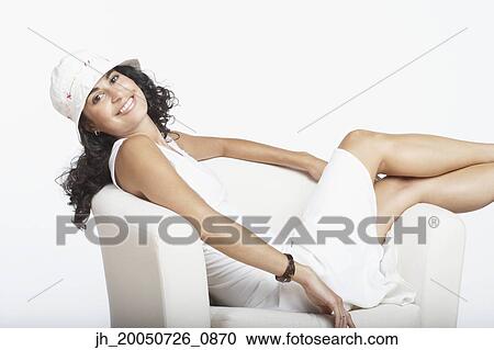 Young woman relaxing in an armchair View Large Photo Image Stock Image - Young woman relaxing in an armchair. Fotosearch