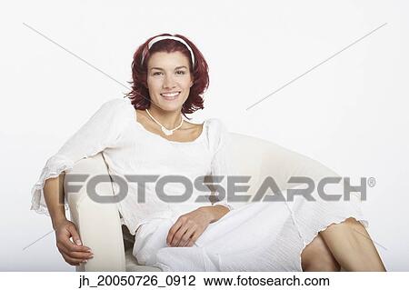 Young woman relaxing in an armchair View Large Photo Image Stock Image - Young woman relaxing in an armchair. Fotosearch