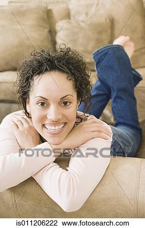Young woman relaxing on a couch View Large Photo Image Stock Image - Young woman relaxing on a couch. Fotosearch
