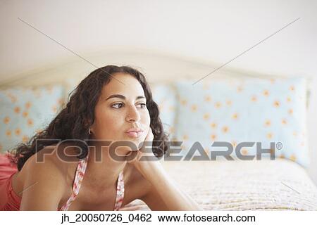 Young woman relaxing on her bed View Large Photo Image Stock Image - Young woman relaxing on her bed. Fotosearch