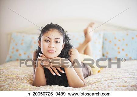 Young woman relaxing on her bed View Large Photo Image Stock Photo - Young woman relaxing on her bed. Fotosearch
