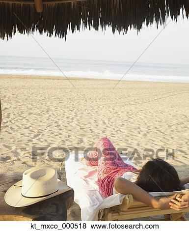 Young woman relaxing on the beach View Large Photo Image Stock Photo - Young woman relaxing on the beach. Fotosearch