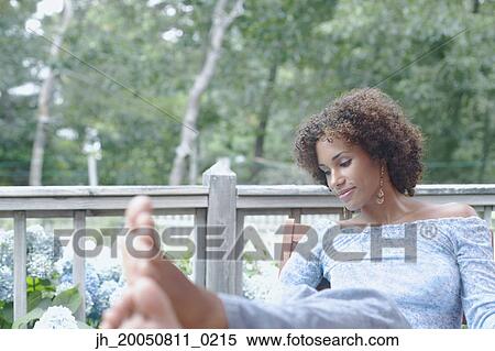 Young woman relaxing outdoors View Large Photo Image Stock Photography - Young woman relaxing outdoors. Fotosearch