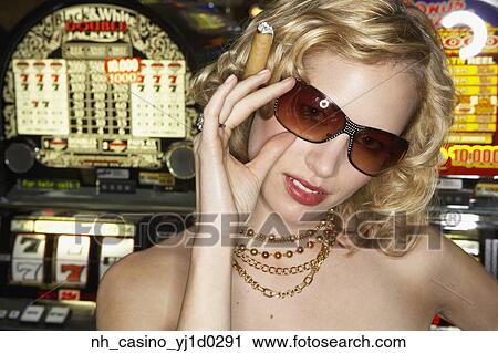 Young woman smoking a cigar in a casino View Large Photo Image Stock Image - Young woman smoking a cigar in a casino. Fotosearch