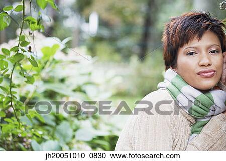 Young woman standing outdoors View Large Photo Image Stock Image - Young woman standing outdoors. Fotosearch