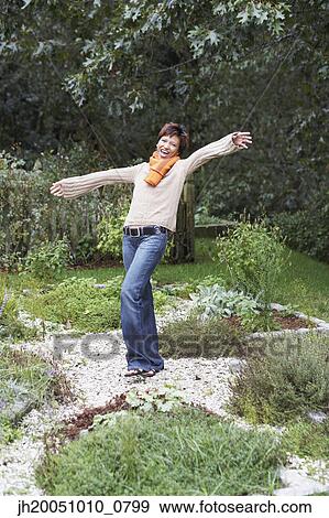 Young woman standing with arms outstretched View Large Photo Image Stock Photo - Young woman standing with arms outstretched. Fotosearch