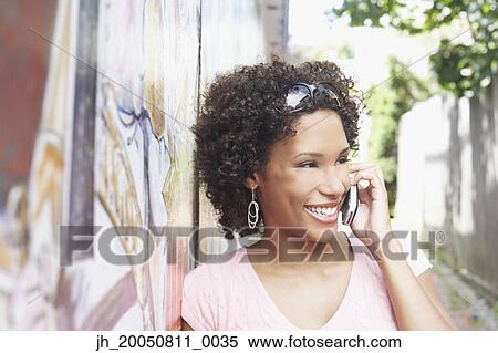 Young woman talking on her cell phone View Large Photo Image Stock Photography - Young woman talking on her cell phone. Fotosearch