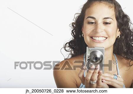 Stock Photo - Young woman using a digital camera. Fotosearch
