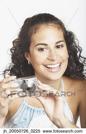 Stock Photography - Young woman using a digital camera. Fotosearch