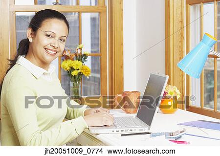 Young woman using a laptop View Large Photo Image Picture - Young woman using a laptop. Fotosearch