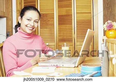 Stock Image - Young woman using a laptop. Fotosearch