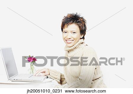 Stock Image - Young woman using a laptop. Fotosearch