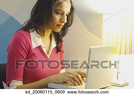 Stock Photo - Young woman using a laptop. Fotosearch
