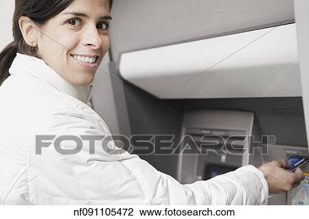 Young woman using an ATM View Large Photo Image Stock Image - Young woman using an ATM. Fotosearch
