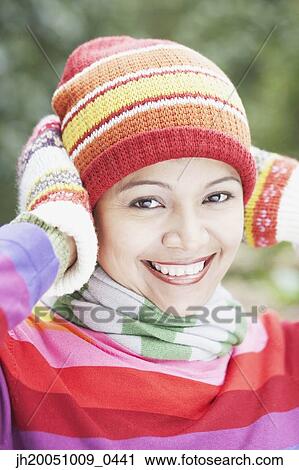 Young woman wearing a hat, scarf and gloves outdoors View Large Photo Image Stock Image - Young woman wearing a hat, scarf and gloves outdoors. Fotosearch