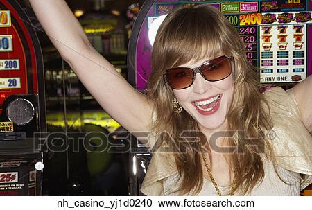 Stock Image - Young woman wearing sunglasses in a casino. Fotosearch