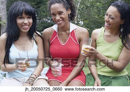 Young women having drinks together View Large Photo Image Stock Image - Young women having drinks together. Fotosearch