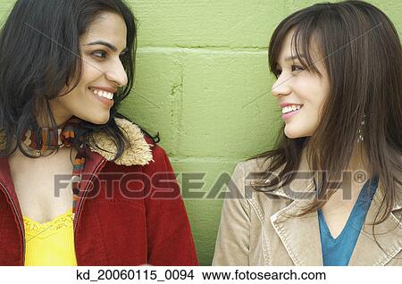 Picture - Young women looking at each other. Fotosearch