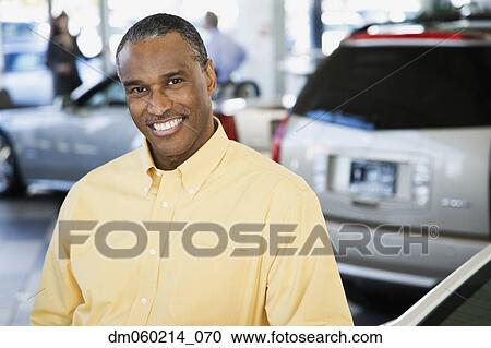 Stock Image - Car salesman smiling. Fotosearch