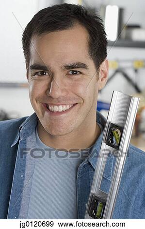 Carpenter holding a ruler View Large Photo Image Stock Photo - Carpenter holding a ruler. Fotosearch