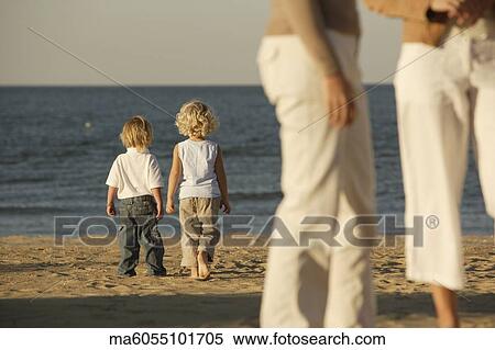 Stock Photography - Children walking on the beach together. Fotosearch