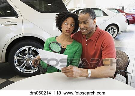 Couple reading the fine print with a magnifying glass View Large Photo Image Stock Photo - Couple reading the fine print with a magnifying glass. Fotosearch