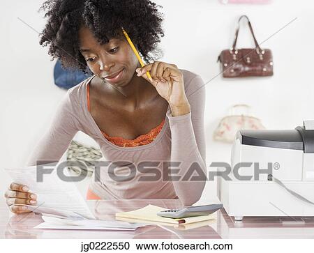 Female employee working behind the counter View Large Photo Image Stock Image - Female employee working behind the counter. Fotosearch