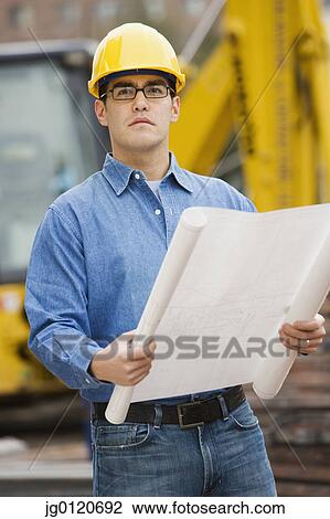 Manual worker examining blueprints View Large Photo Image Stock Image - Manual worker examining blueprints. Fotosearch
