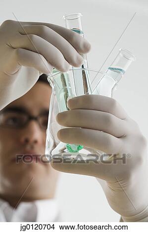 Scientist examining chemicals in test tubes View Large Photo Image Picture - Scientist examining chemicals in test tubes. Fotosearch