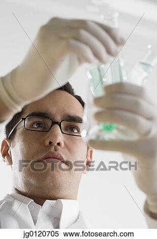 Stock Photography - Scientist examining chemicals in test tubes. Fotosearch