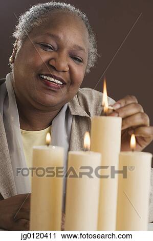 Senior woman lighting candles View Large Photo Image Stock Image - Senior woman lighting candles. Fotosearch